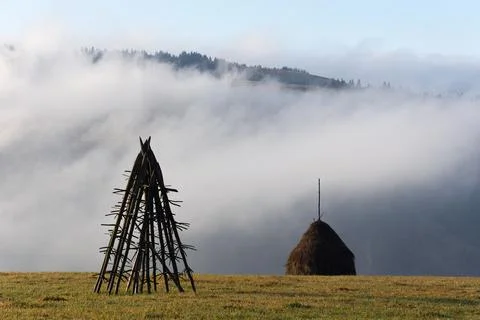 Rural landscape with a stack of dry hay in the field of mountain Stockfoto's