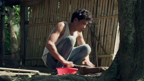 Rural man sharpening knife with stone, Laos Stock Footage 134294950
