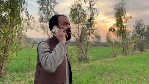 Rural Man Talking on Phone at Sunset in Countryside Vídeos de archivo 335590358