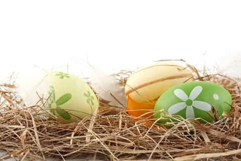 Rural pastel colored easter eggs in the hay isolated on white Stock Photos