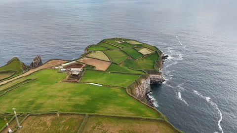 Rural patchwork fields above volcanic rocky shoreline with Atlantic Ocean Stock-Footage 331261414
