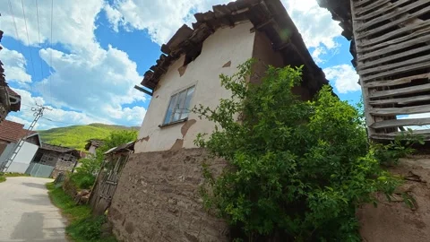 Rural path winds past weathered wooden homes. Dojkinci village, Serbia Vídeos de archivo 335534130