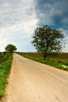 Rural road and cloudy dramatic sky Stock Photos
