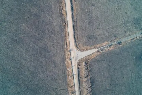Rural road intersection T-junction in a desolate winter field, transport Stock Photos
