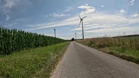 Rural Road Leading Through Cornfield Toward Wind Turbines in Germany Stock Footage 340913330