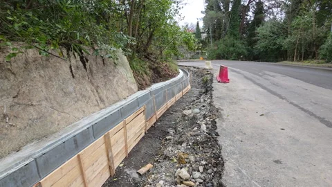 Rural roadwork with safety features. Maintenance activity involving curb Vídeos de archivo 330438364