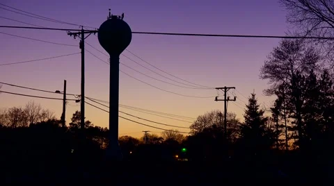 A rural water tank above a small town in dusk glow. Stock Footage