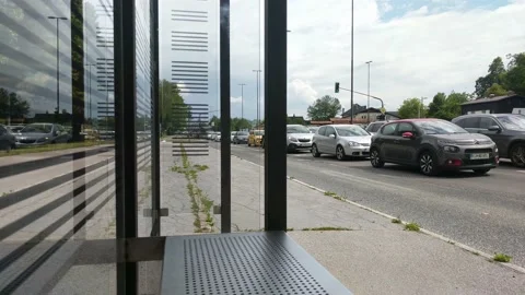 Rush hour slow moving traffic with cyclists driving by bus station. Stock Footage 132980726