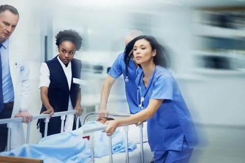 Rushing to the ER. Shot of a group of medical professionals rushing a patient on Stock Photos