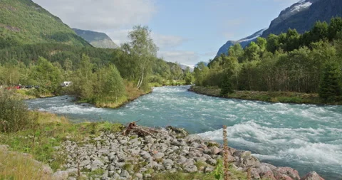 Rushing glacial river flowing through norwegian valley landscape Video stock 326354106