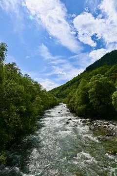 Rushing Mountain River Flowing Through a Lush Green Valley Stock Photos