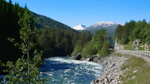 A rushing mountain stream flows through rock and forest trees. Stock Footage 116488375
