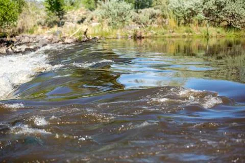 Rushing river rapids smooth flow over rocks with reflections Stock Photos