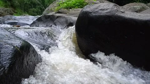 The rushing river water flow through the black rocks Stock-Footage 171195931