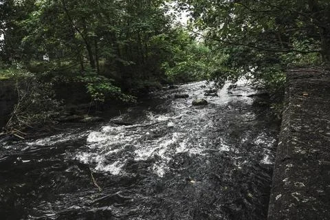 Rushing streams of a small river flow through natural obstacles Stock Photos