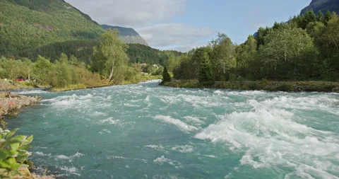 Rushing turquoise river flowing through norway valley landscape Stockbeeldmateriaal 325910305