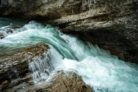 Rushing turquoise waters cascading over natural rock formations Stock Photos