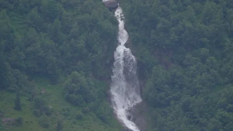 Rushing water rushes down the Alpine slopes due to the melting snow Stock Footage 247571341