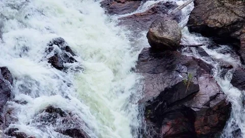 Rushing waterfall through a rocky mountain canyon in a location resembling 库存影片 334100066