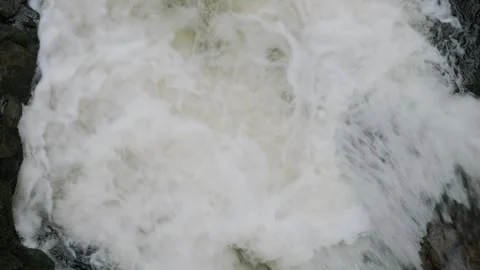 Rushing white water cascades down rocky terrain Stock Footage 306392880