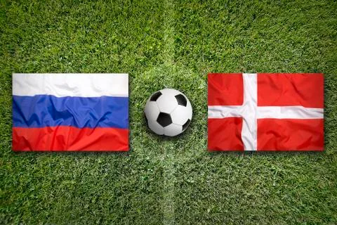 Russia vs. Denmark flags on soccer field Stock Photos