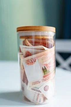 Russian banknotes of 5000 rubles packed in a glass jar on a kitchen. Business Stock Photos