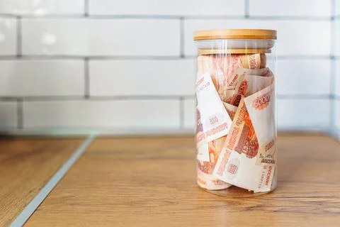 Russian banknotes of 5000 rubles packed in a glass jar on a kitchen. Business Stock Photos