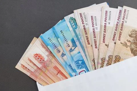 Russian banknotes in an envelope on a gray background. Concept of a bribe. Gray Stock Photos