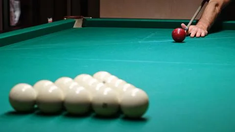 Russian billiards on a green pool table. A player hits the red ball with a .. Stock Photos