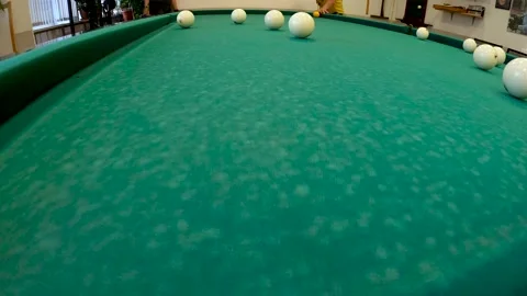 Russian billiards, a man at the far side hits the ball with a cue. Video Stock Footage 163429751