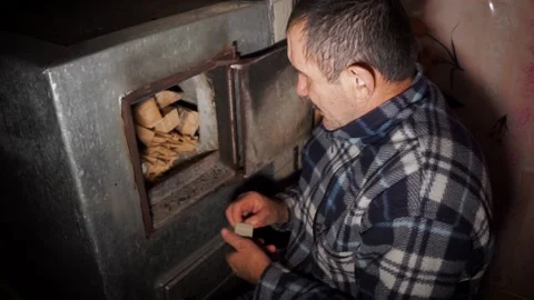 Russian brutal man makes a fire in the oven Stock Footage 97894459