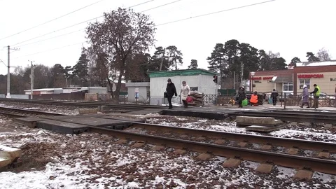 Russian commuters cross an open level crossing near Moscow to get to a commuter  Stock Footage 82902704
