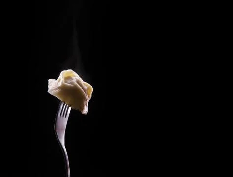 Russian dumpling sprinkled with pepper on fork Stock Photos