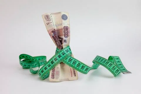 The Russian five-hundred-ruble note is wrapped in a measuring tape. The conce Stock Photos