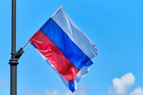 The Russian flag develops from the wind against the background of the sky Foto stock