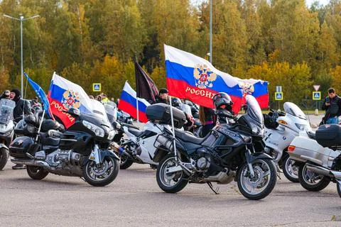 Russian flag with double-headed eagle symbol on motorcycle with man. Patriotic Stock Photos