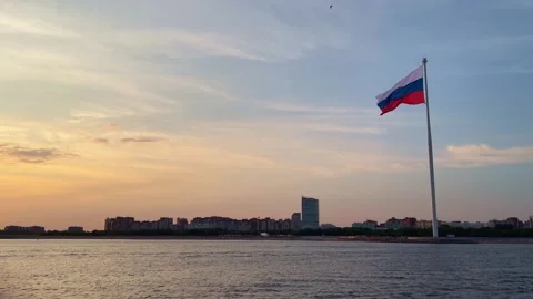 The Russian flag on a flagpole flutters in the wind against the sunset sky. Near Stock Footage 306881359