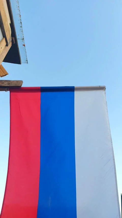 The Russian flag flutters in the wind against the blue sky. Holiday Stock Footage 240658003