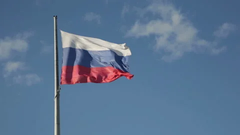 Russian flag flutters in the wind on the flagpole on blue sky background Stock Footage 94687052