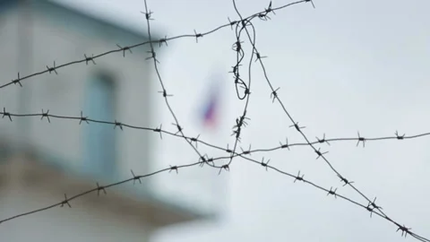 Russian flag swaying in the wind over the border tower with barbed wire Stock Footage 98358783
