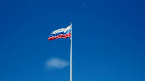 The Russian flag waving in the wind against the blue cloudless sky. Stock Footage 155568060