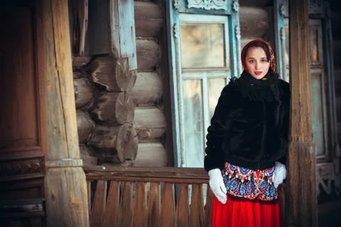 Russian girl in the winter in the village near the old house. Beautiful woman Stock Photos