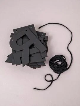 Russian letters in a stack, letter I on top and a black rope on a gray back.. 스톡 사진