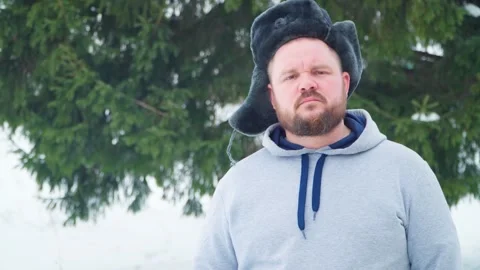 A Russian man with a beard and a winter hat with earflaps. Video stock 263051865