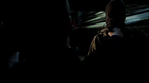 Russian man in a hat with earflaps, talking on the phone in a dark basement and Stock Footage 107325027