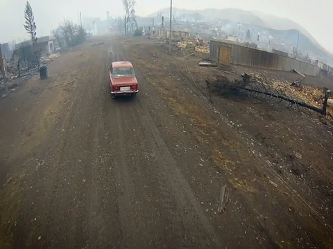 Russian Old Car Lada on Going a Dirt Road. View of the Burned Village. Aerial Stock Footage 71529929
