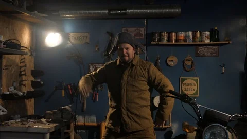 The Russian peasant is dancing in a padded jacket, a hat with earflaps and felt Stock Footage 107326455