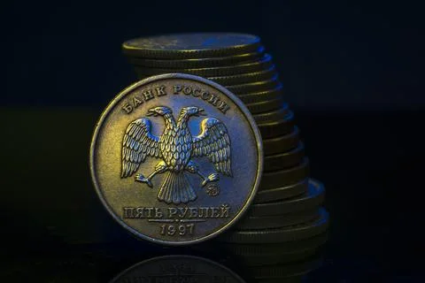 Russian Ruble Coins with falling Stack. Ukrainian flag colors illuminating. U Stock Photos