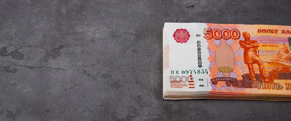 Russian rubles a large bundle on a gray background. A bundle of five-thousand Stock Photos