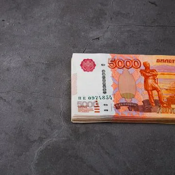 Russian rubles a large bundle on a gray background. A bundle of five-thousand Stock Photos